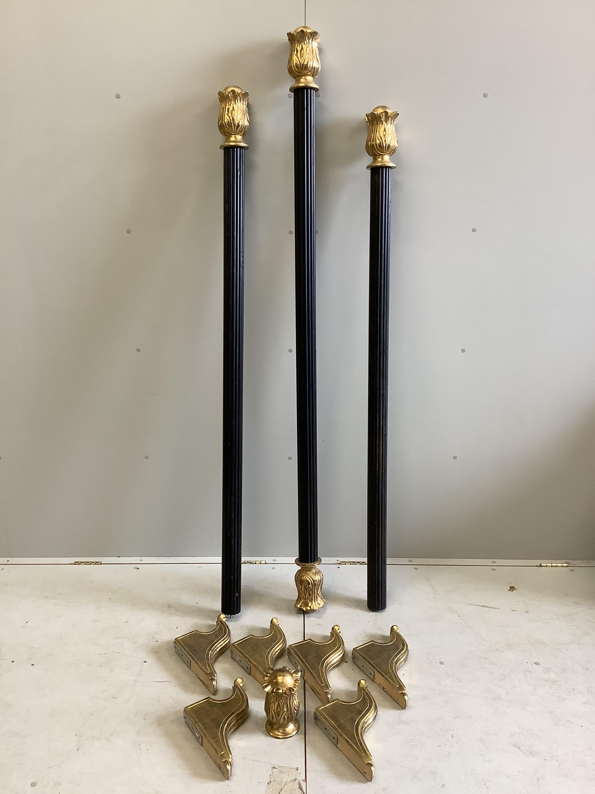 A set of three Regency style carved giltwood and ebonised curtain poles with brackets, largest 198cm